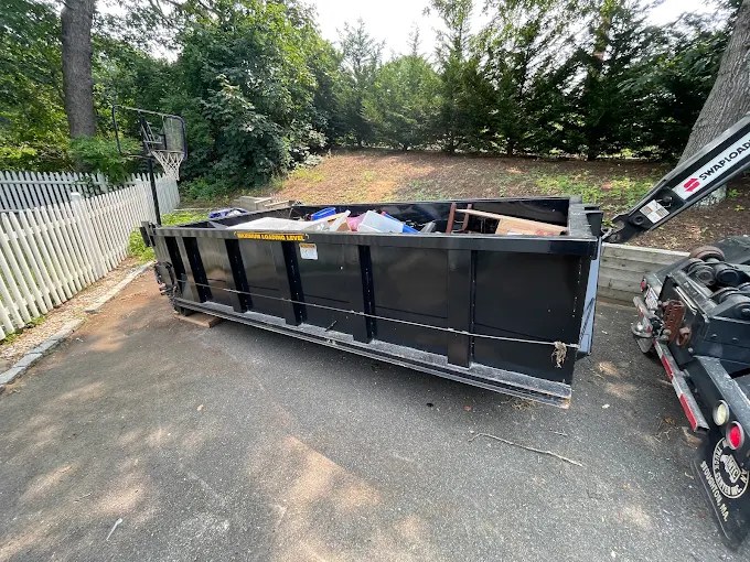 Coastline Disposal dumpster in a driveway during drop-off