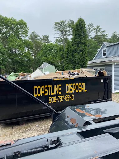 Loaded Coastline Disposal dumpster at a residential job on Cape Cod