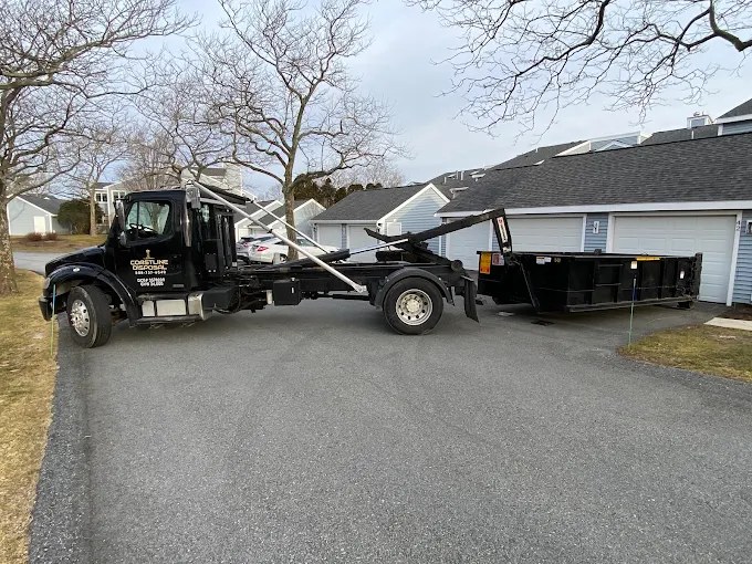 Coastline Disposal roll-off truck dropping a dumpster at a Cape neighborhood